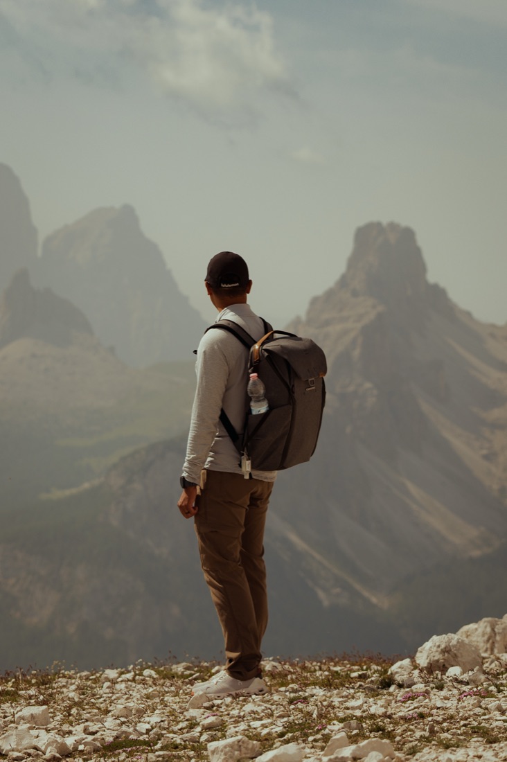 George from behind on a rocky ridge, looking out at hazy Dolomite peaks
